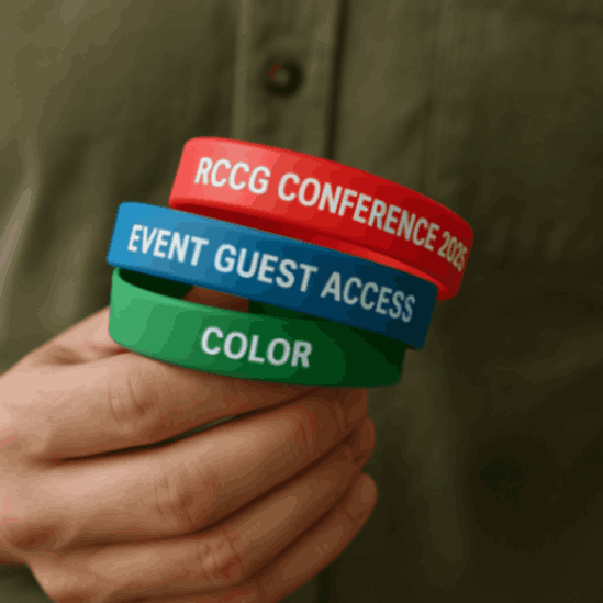 Wristband printing in Nigeria showing colorful silicone and paper wristbands stacked on a wooden surface with a blurred background.