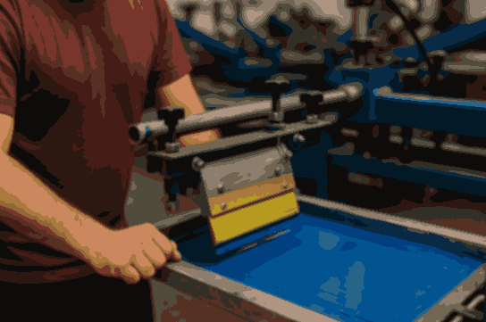 A worker operating a screen printing machine in a U.S. factory – ideal for screen printing jobs in USA with visa sponsorship.